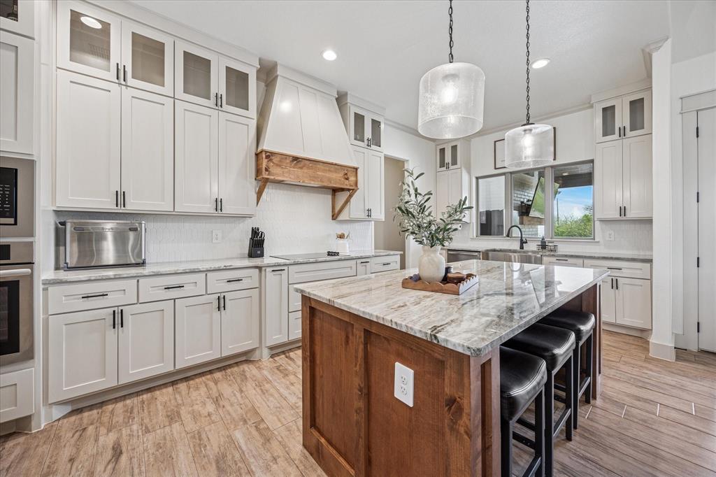 2028 Carrie Court Weatherford, TX 76088 - Photo 14 of 40 a kitchen with stainless steel appliances granite countertop a kitchen island a stove and a sink