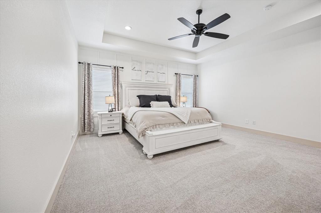 2028 Carrie Court Weatherford, TX 76088 - Photo 19 of 40 a spacious bedroom with a bed and a ceiling fan