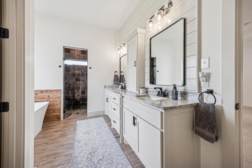 2028 Carrie Court Weatherford, TX 76088 - Photo 21 of 40 a bathroom with a granite countertop sink a mirror and shower