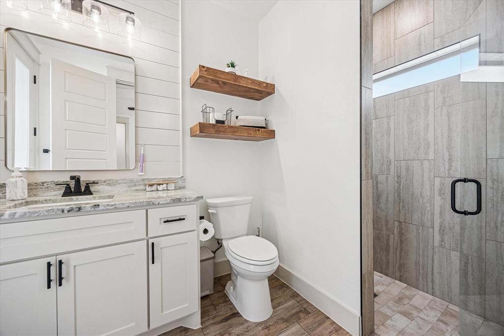 2028 Carrie Court Weatherford, TX 76088 - Photo 32 of 40 a bathroom with a granite countertop sink toilet and shower