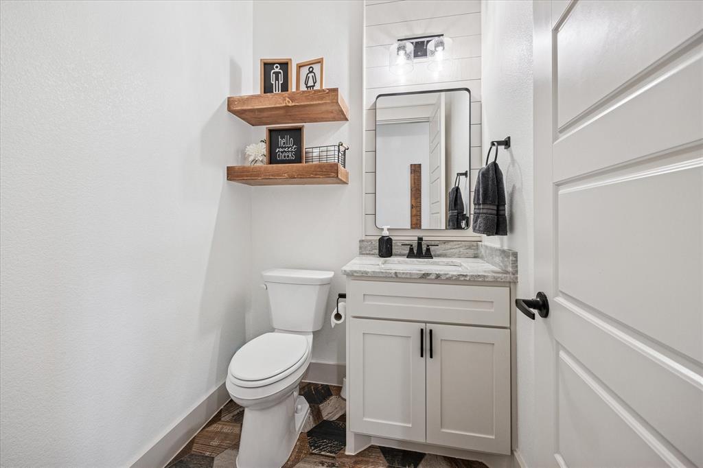 2028 Carrie Court Weatherford, TX 76088 - Photo 33 of 40 a bathroom with a toilet sink and mirror