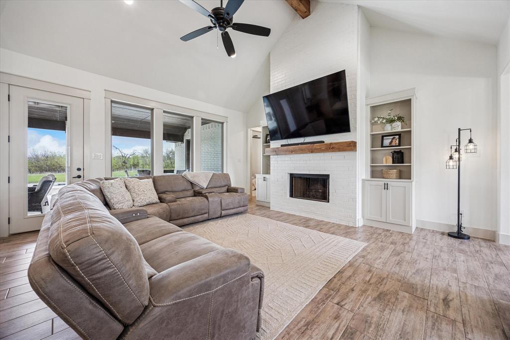 2028 Carrie Court Weatherford, TX 76088 - Photo 8 of 40 a living room with furniture a flat screen tv and a fireplace