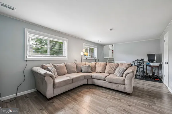 a living room with furniture and a flat screen tv with wooden floor