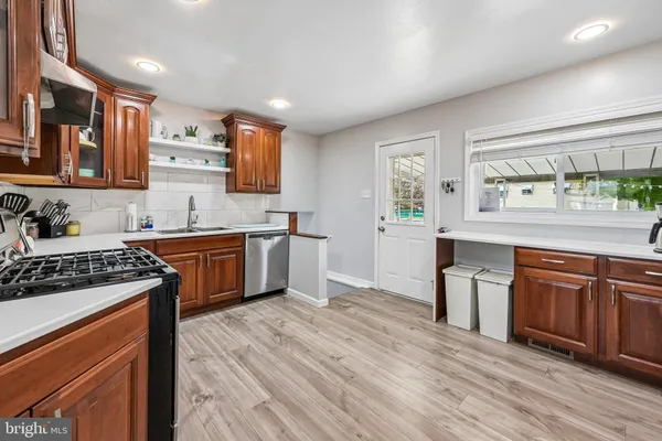 a kitchen with stainless steel appliances granite countertop wooden cabinets and a stove top oven