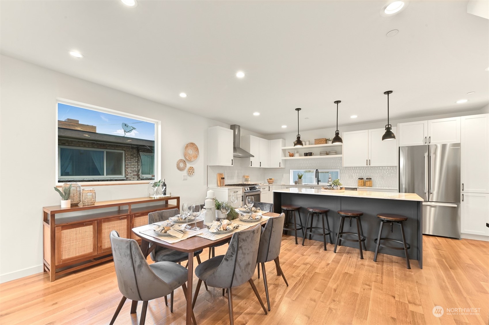 422 14th Avenue East, Unit B Seattle, WA 98112 - Photo 11 of 24 a dining hall with stainless steel appliances kitchen island granite countertop a dining table and chairs with wooden floor