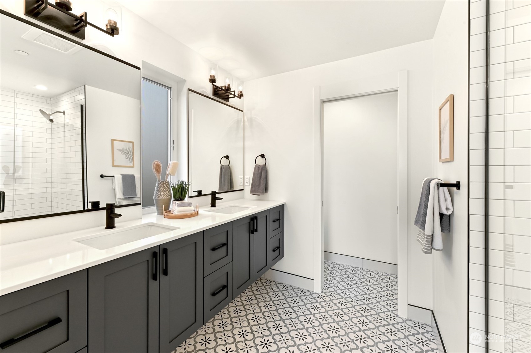 422 14th Avenue East, Unit B Seattle, WA 98112 - Photo 17 of 24 a bathroom with a double vanity sink a mirror and a shower