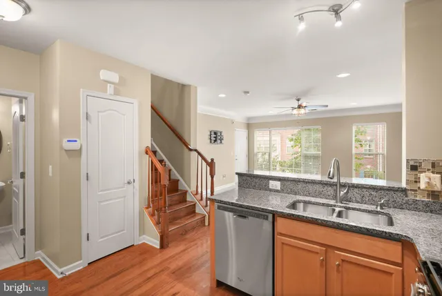 a kitchen with granite countertop a sink and dishwasher with wooden floor