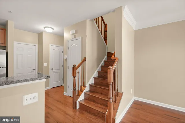 a view of a hallway with wooden floor and staircase