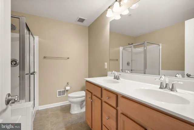 a bathroom with a sink a toilet and a large mirror