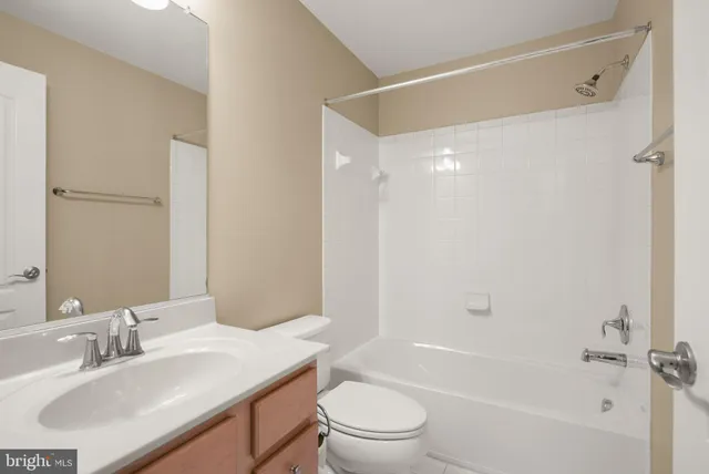 a bathroom with a bathtub shower sink vanity mirror and toilet