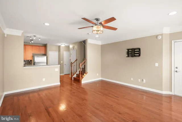 a view of a room with wooden floor and a ceiling fan