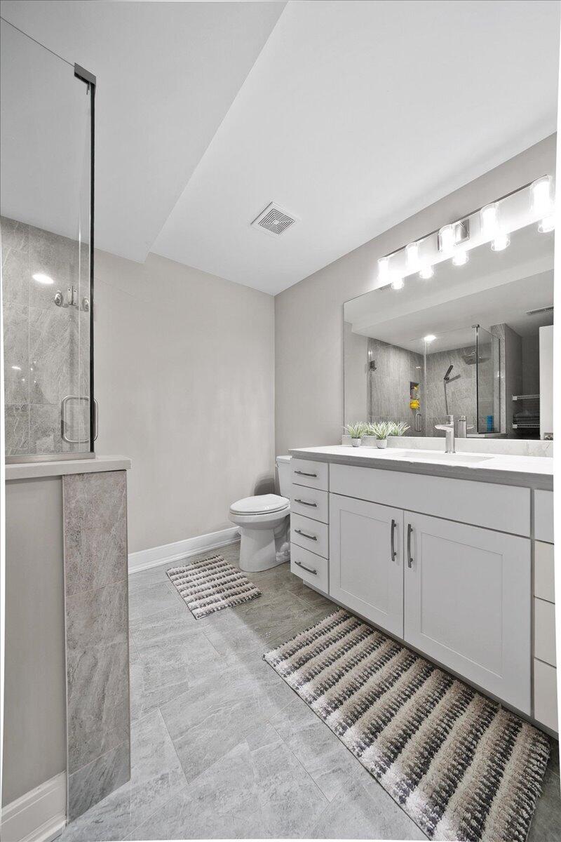 9317 Michigan Drive Crown Point, IN 46307 - Photo 32 of 42 a spacious bathroom with a double vanity sink a mirror and a toilet