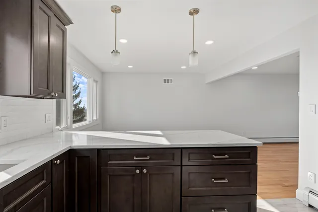 a bathroom with a sink and a large mirror next to a window