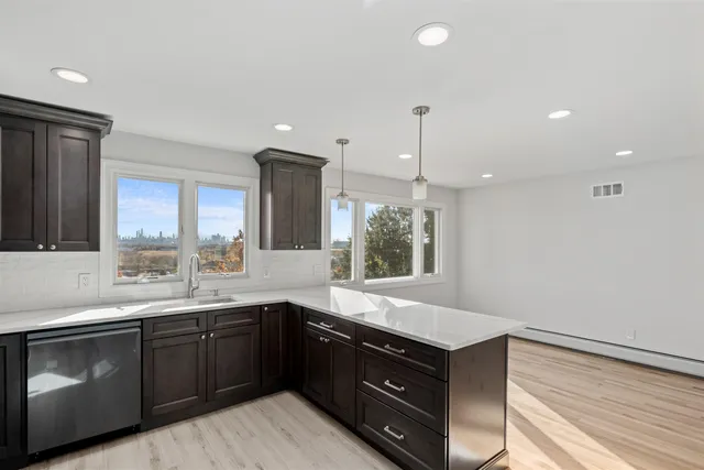 a kitchen with kitchen island stainless steel appliances a sink counter space and a window