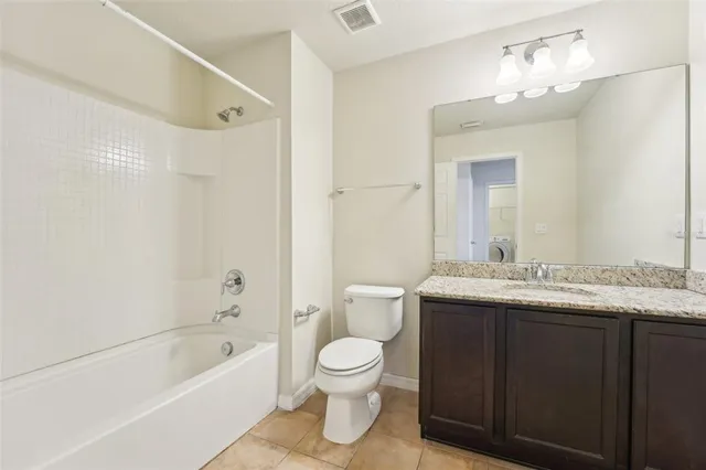 a bathroom with a granite countertop sink toilet a large mirror a bathtub and shower