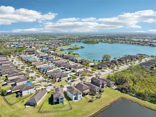 an aerial view of residential houses with outdoor space and ocean view