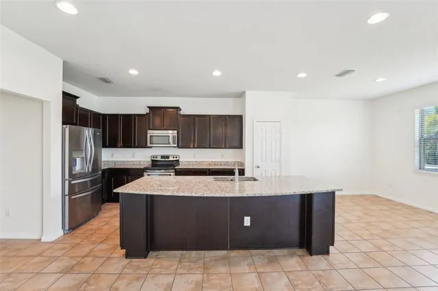 a kitchen with stainless steel appliances granite countertop a stove a sink a refrigerator and a oven