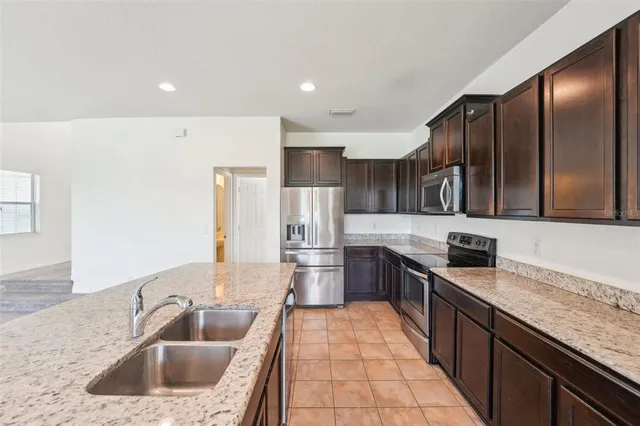 a kitchen with stainless steel appliances granite countertop a sink stove and refrigerator