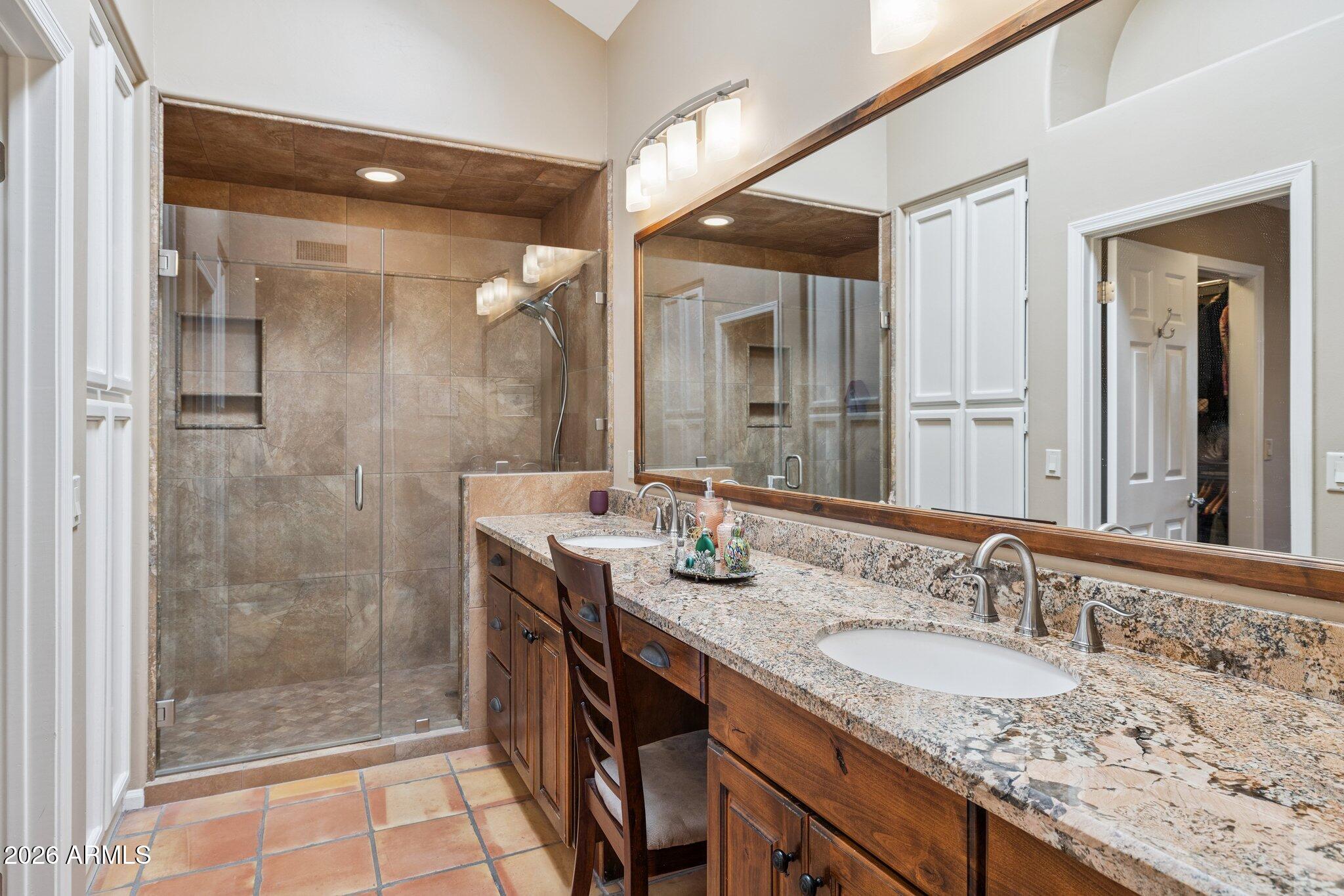 8100 East Camelback Road, Unit 129 Scottsdale, AZ 85251 - Photo 6 of 13 a bathroom with a granite countertop sink a mirror and shower
