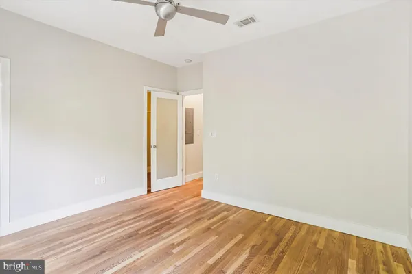 a view of a room with wooden floor and a bathroom