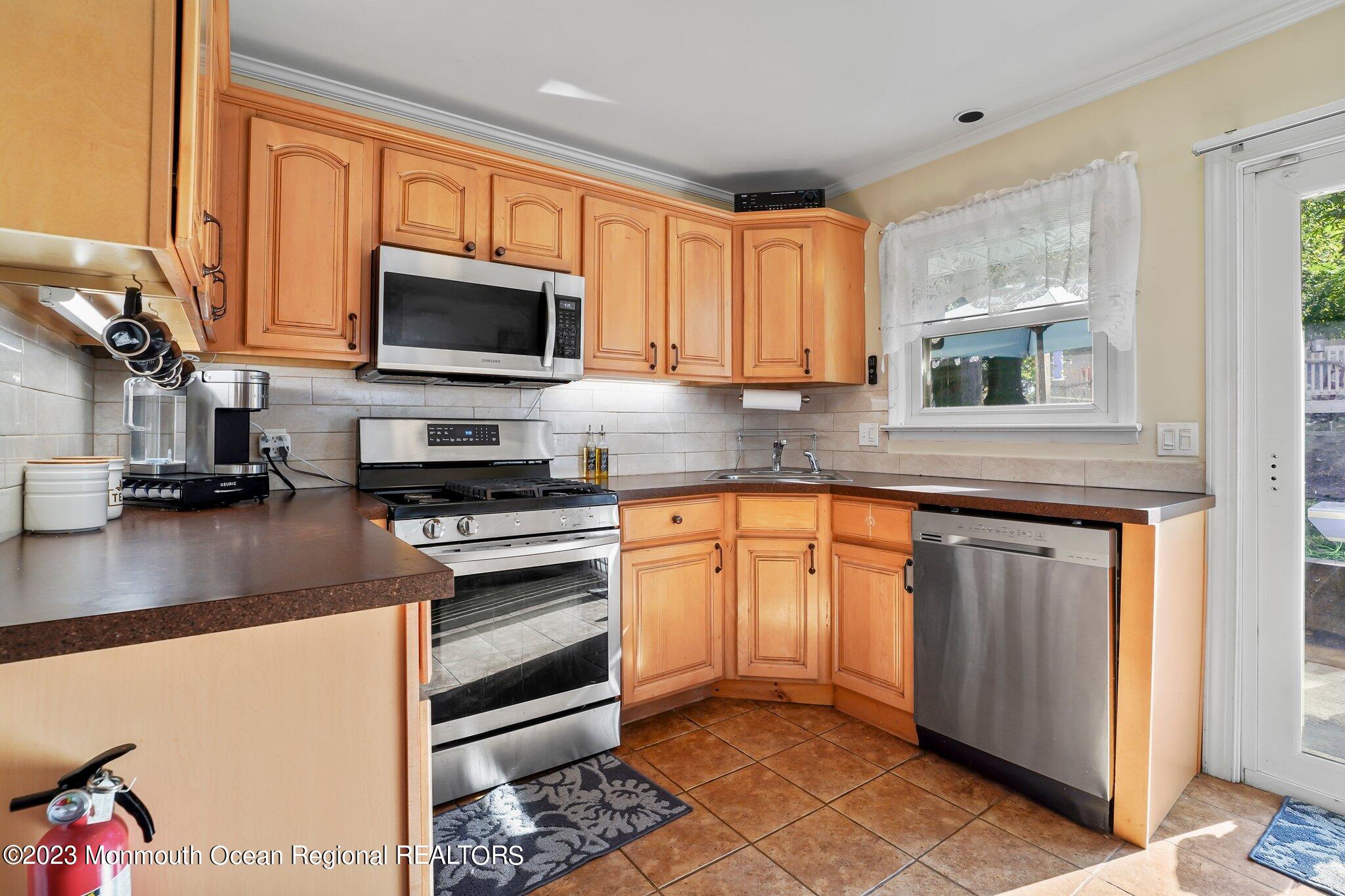 819 Shore Concourse Keyport, NJ 07735 - Photo 10 of 26 a kitchen with stainless steel appliances granite countertop a stove a sink and a microwave