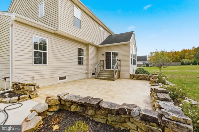 a view of a patio with table and chairs near a yard