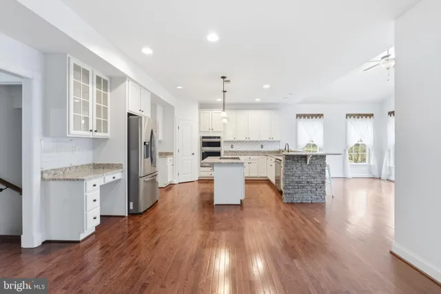 a kitchen with a refrigerator and a stove top oven
