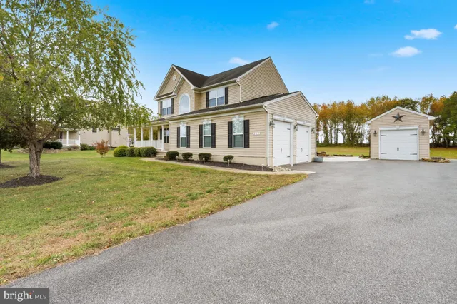 a front view of a house with a yard and trees