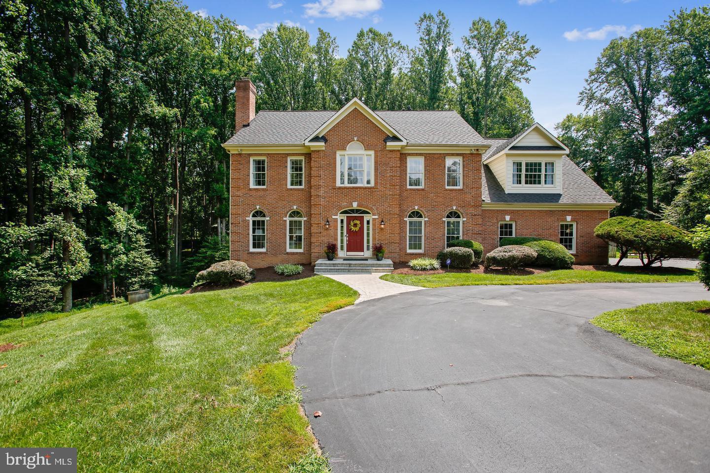 a front view of a house with a yard and trees