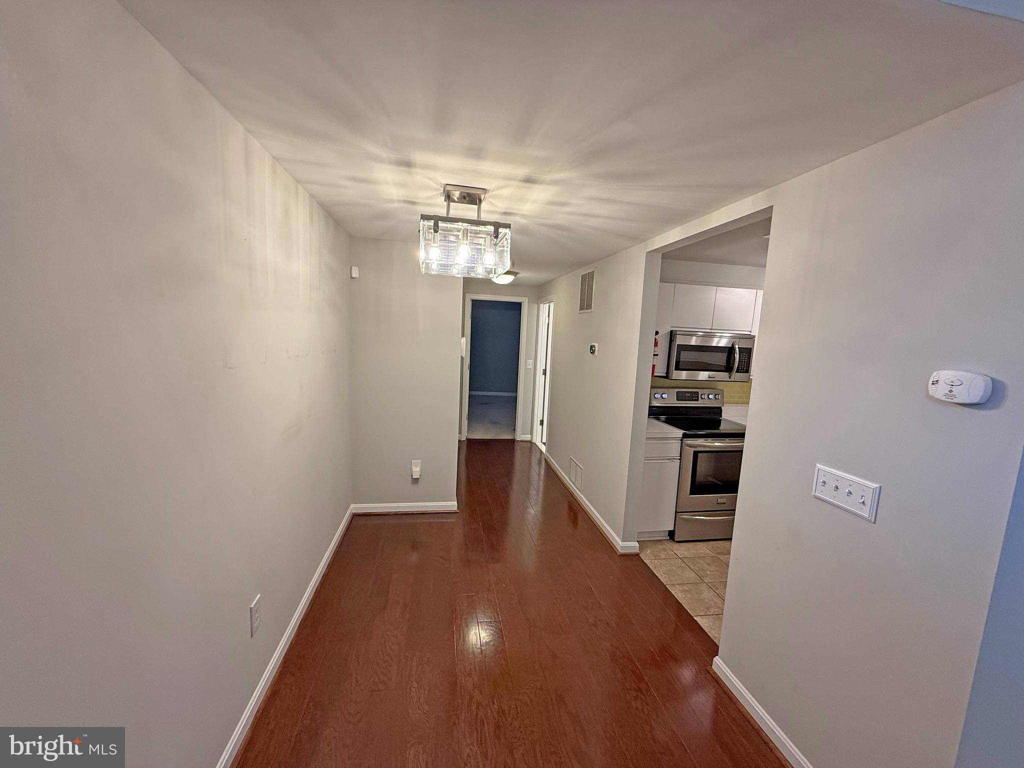 402 Grindall Street, Unit A Baltimore, MD 21230 - Photo 11 of 18 a view of a hallway with wooden floor and chandelier