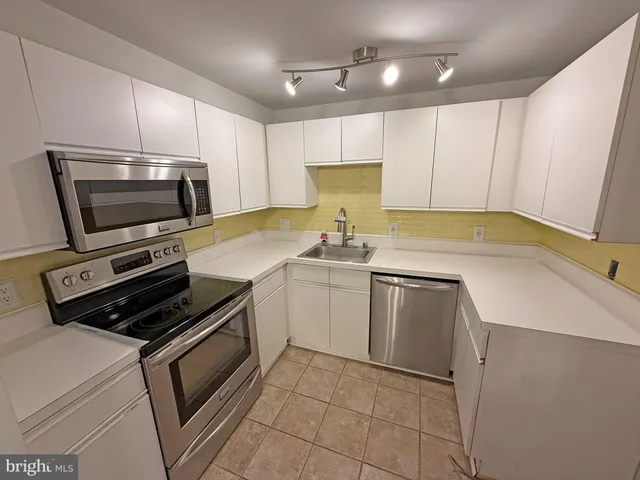 an empty room with a ceiling fan and carpet