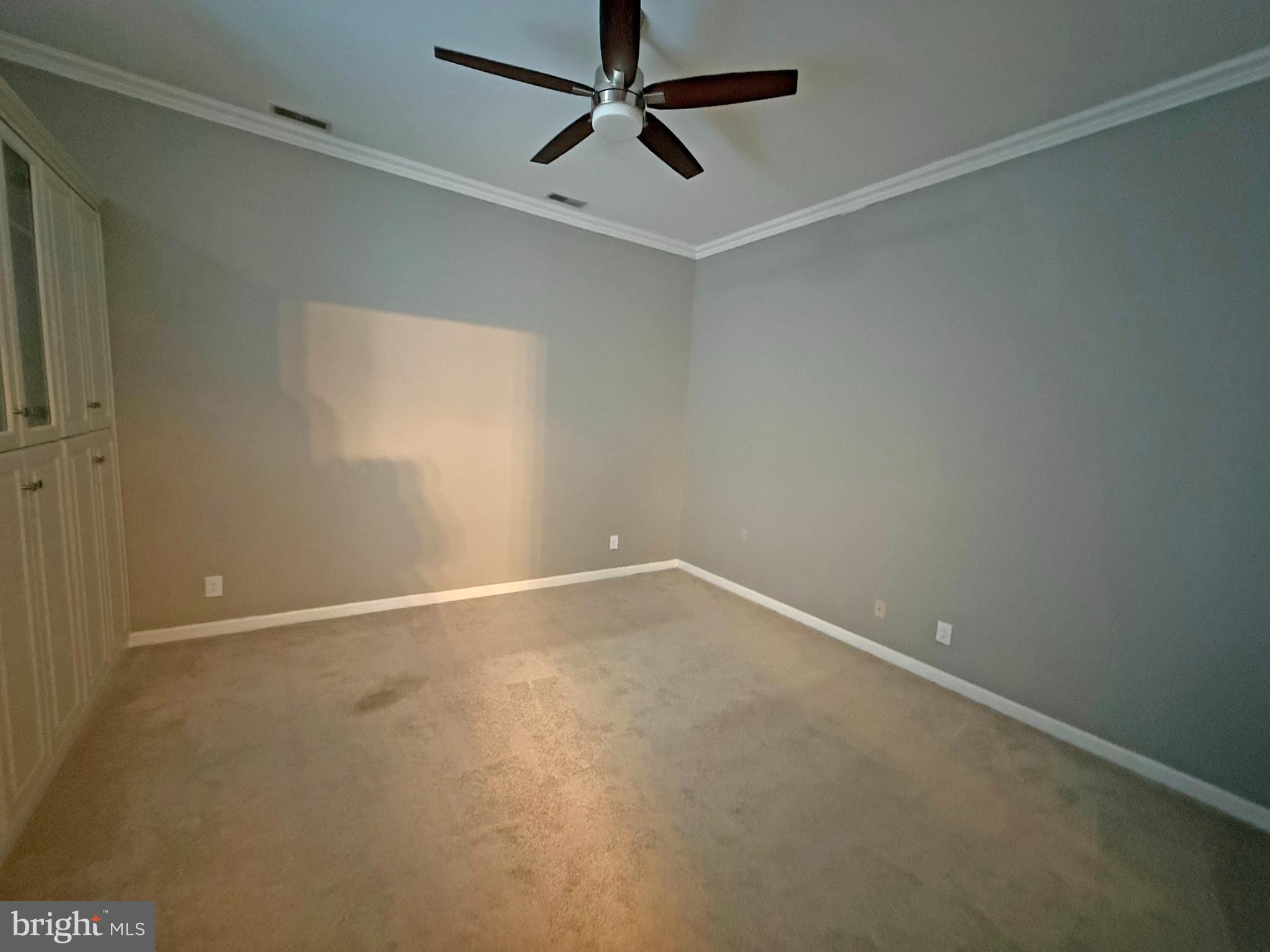 402 Grindall Street, Unit A Baltimore, MD 21230 - Photo 14 of 18 an empty room with a ceiling fan and carpet