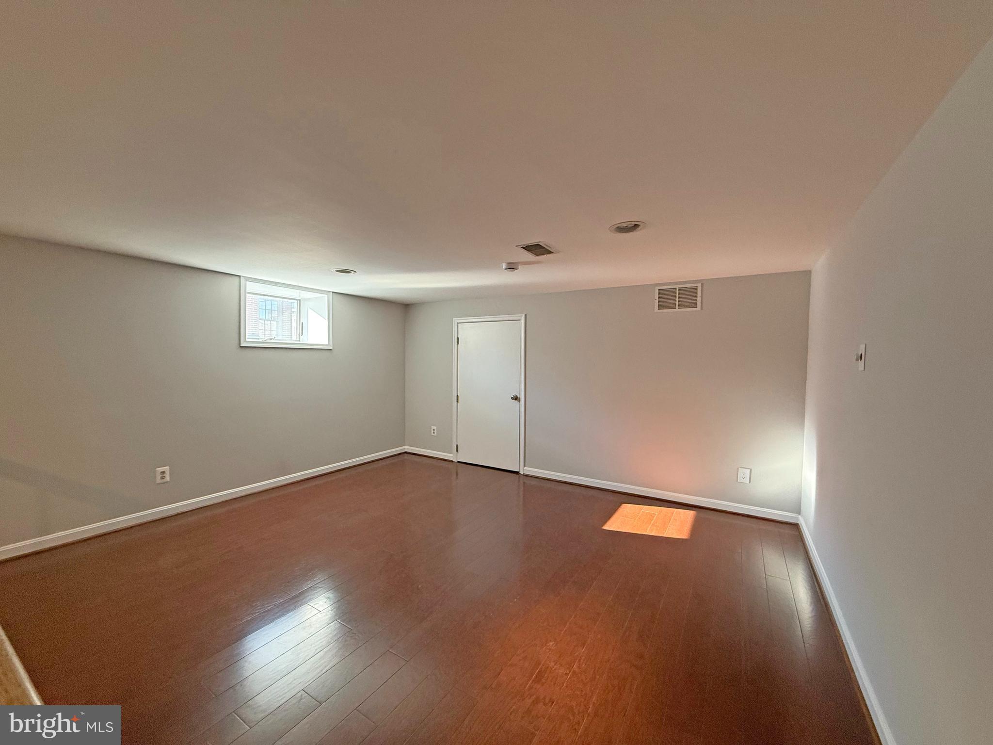 402 Grindall Street, Unit A Baltimore, MD 21230 - Photo 8 of 18 an empty room with wooden floor and windows