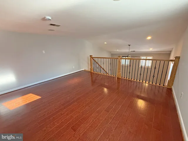 a view of a hallway with wooden floor and chandelier