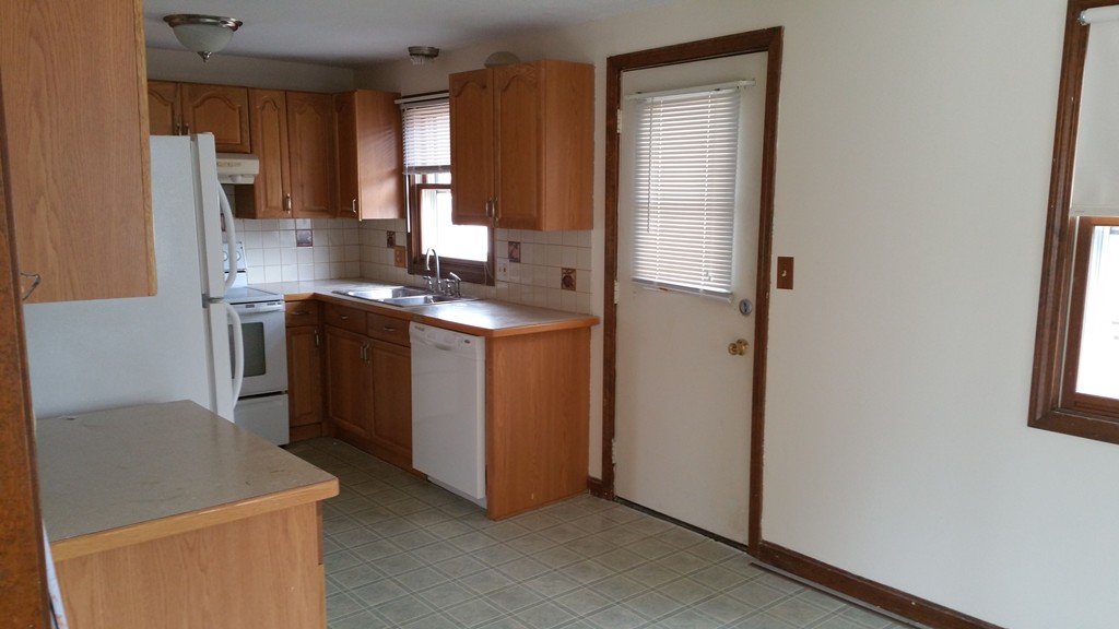 10 Labelle Drive Springfield, MA 01129 - Photo 4 of 7 a kitchen with stainless steel appliances a stove a refrigerator a sink and white cabinets with wooden floor