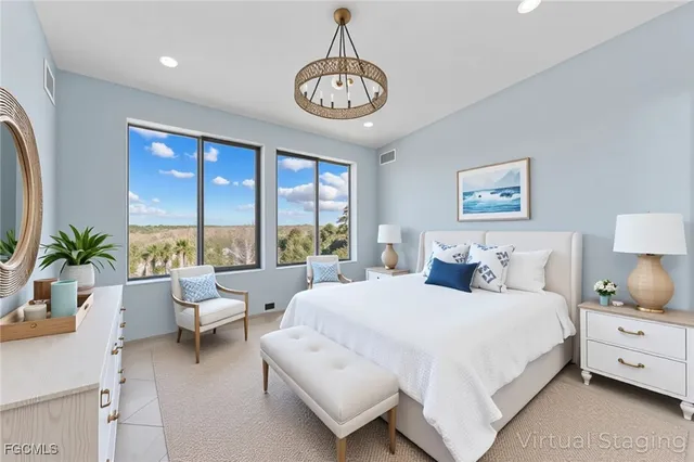 a bedroom with a large bed and a chandelier