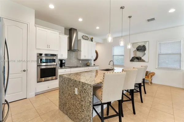a large kitchen with a table chairs and a refrigerator
