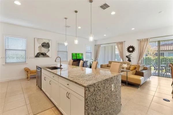 a large kitchen with kitchen island a stove a sink a table and chairs