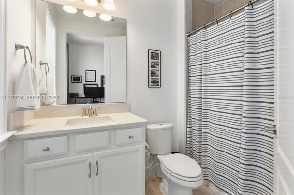 a bathroom with a toilet a sink and mirror
