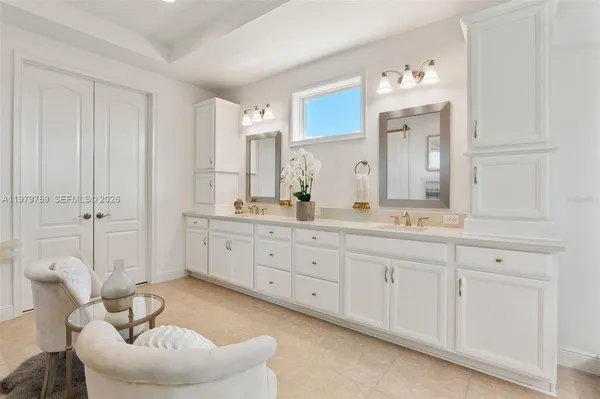 a spacious bathroom with a double vanity sink a mirror and a