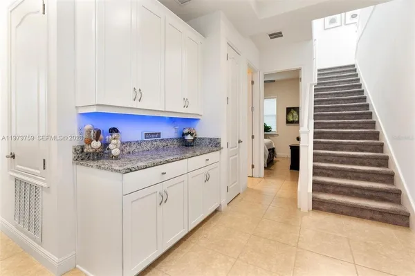 a kitchen with granite countertop white cabinets and stainless steel appliances
