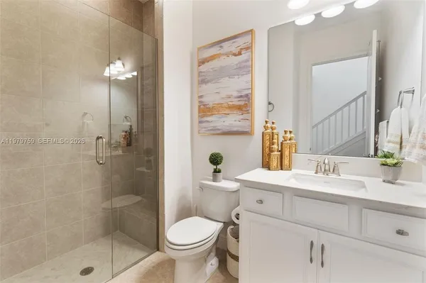 a bathroom with a sink toilet a mirror and shower
