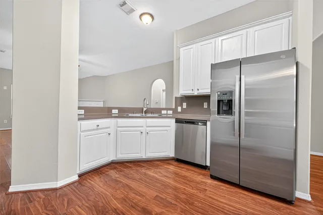a kitchen with a refrigerator sink and cabinets