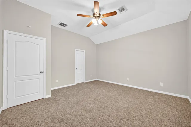 an empty room with chandelier fan