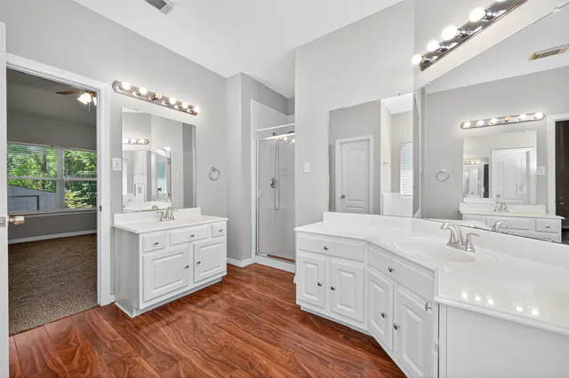 a bathroom with a double vanity sink mirror and bathtub