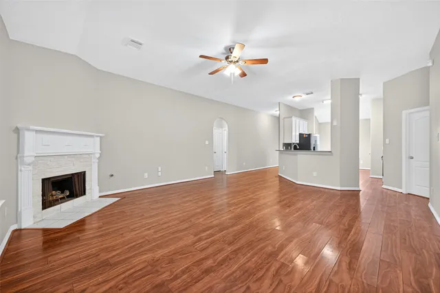 a view of empty room with wooden floor and fireplace