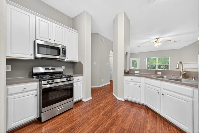 a kitchen with stainless steel appliances granite countertop a stove a sink and a microwave