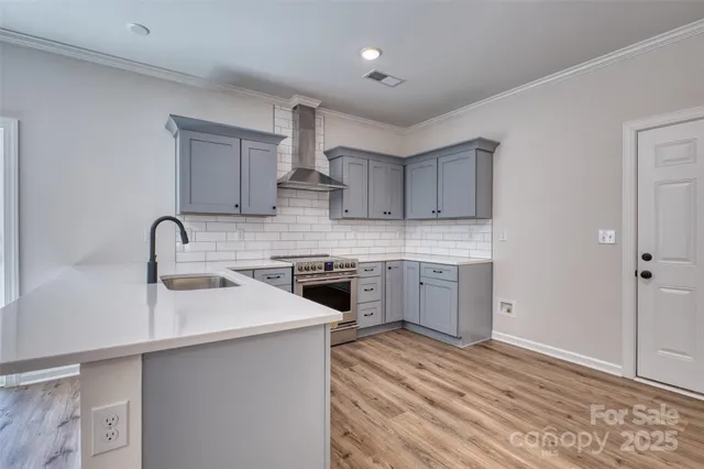 a view of a kitchen with a sink and wooden floor