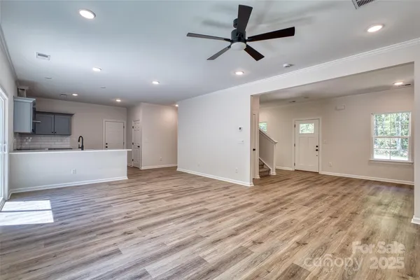 a view of an empty room with window and wooden floor