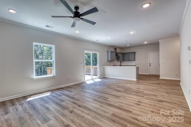 a view of empty room with wooden floor and window
